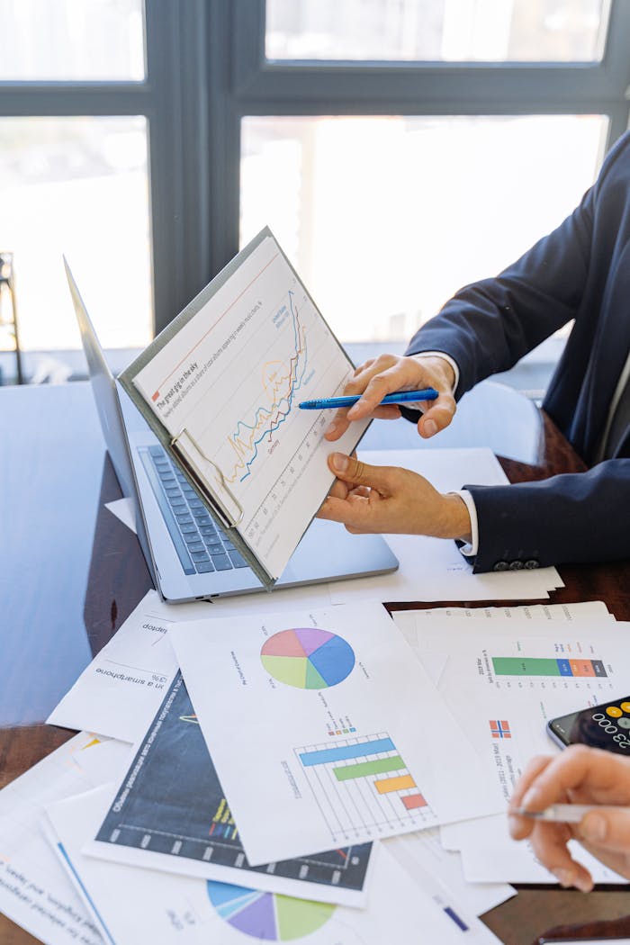 our-journey-02 Business professionals discussing financial graphs and charts in an office setting.